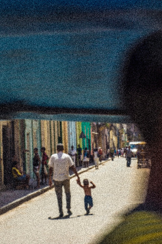 father and child walking on a cuban street